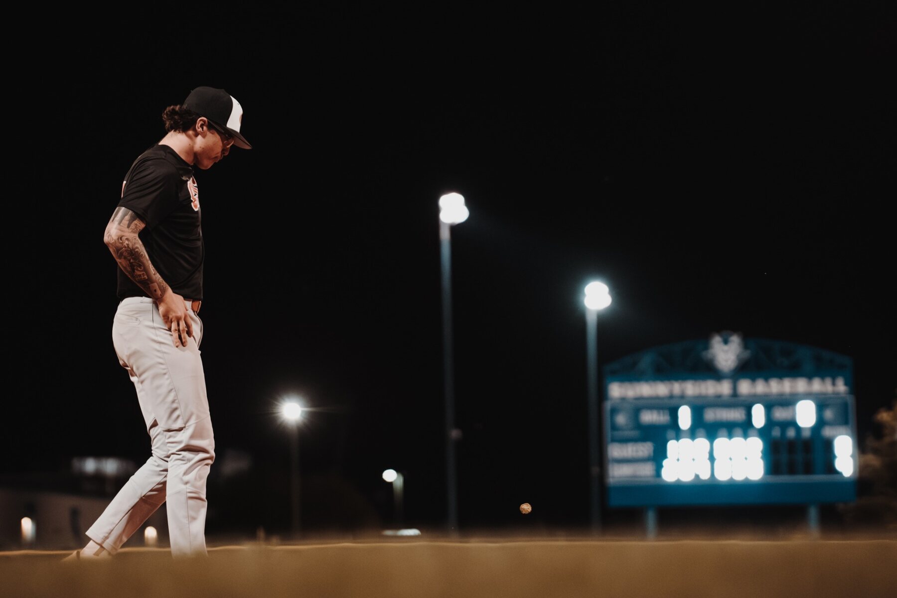 Baseball player walking on a field at night